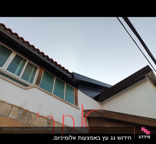 גג רעפים אדום עם חלונות זכוכית מתחתיו